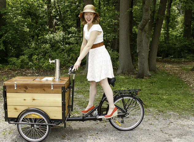 Woman riding a cedar cargo box Icicle Tricycles Cold Brew Coffee Bike in the woods