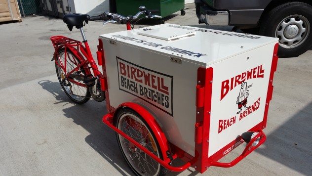 An icicle Tricycles Ice Cream bike with a red frame and a graphic printed box.