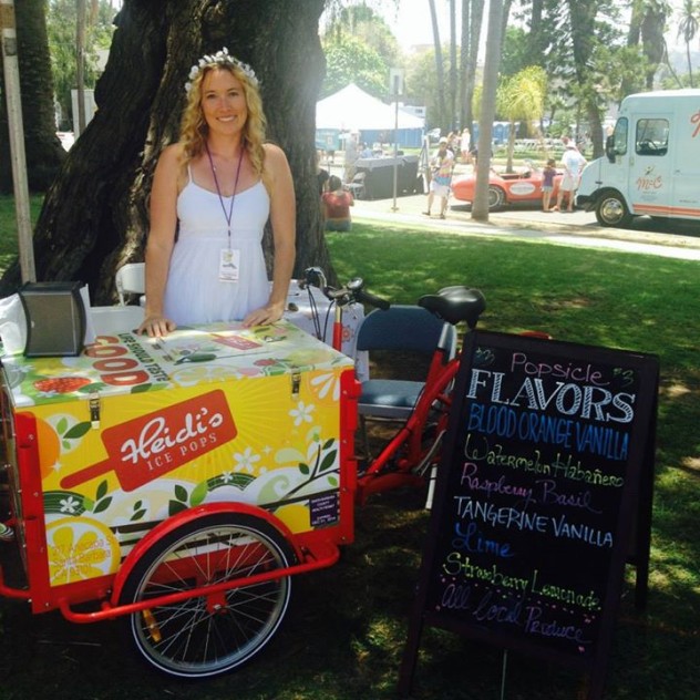 Woman posing behind an ice cream cart branded for Heidi's at a popup event