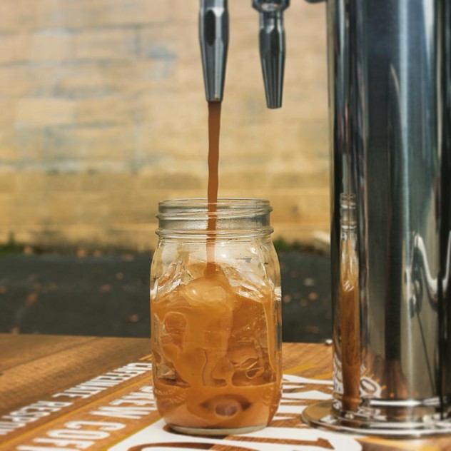 nitro cold brew coffee pouring straight from the tap on the lid of a coffee cart
