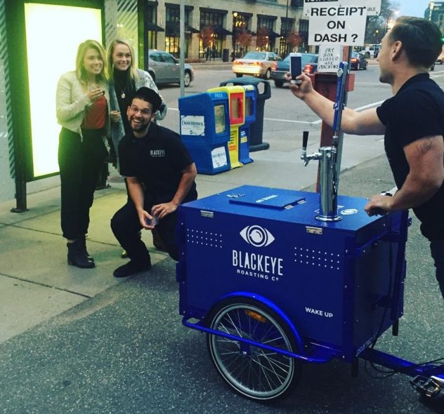 A group of young people smiling in front of a cold brew coffee tap ice cream bike / trike with custom branding in new york city