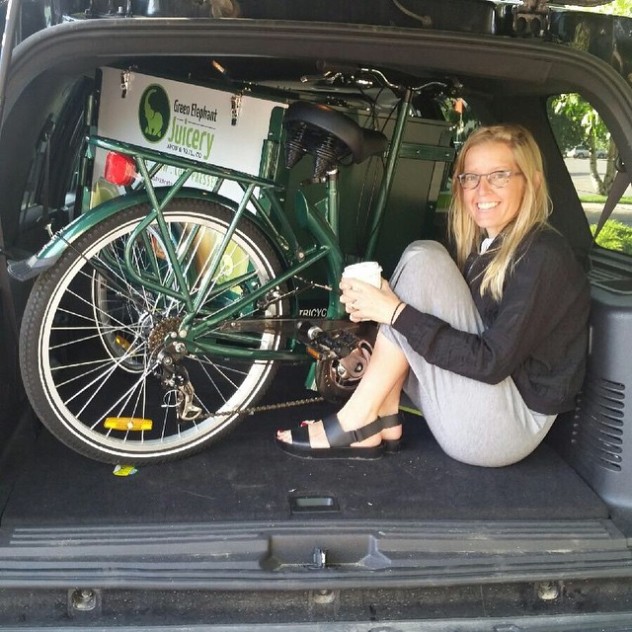 An Icicle Tricycles Ice Cream Bike in the back of a Honda Element with a person holding coffee