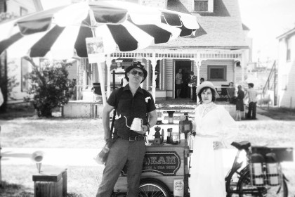 two coffee crafters posing with their Stream Coffee and Teas branded Icicle Tricycles Coffee Cargo Bike on the curb in a neighborhood in black and white