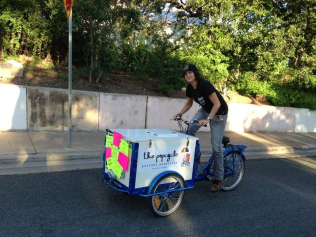 an Ice Cream Bike / Trike By Icicle Tricycles with a blue frame rolling down the street