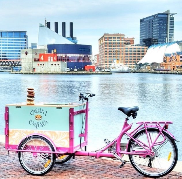 a custom wrapped icicle tricycle ice cream bike parked next to the water in Baltimore Maryland 