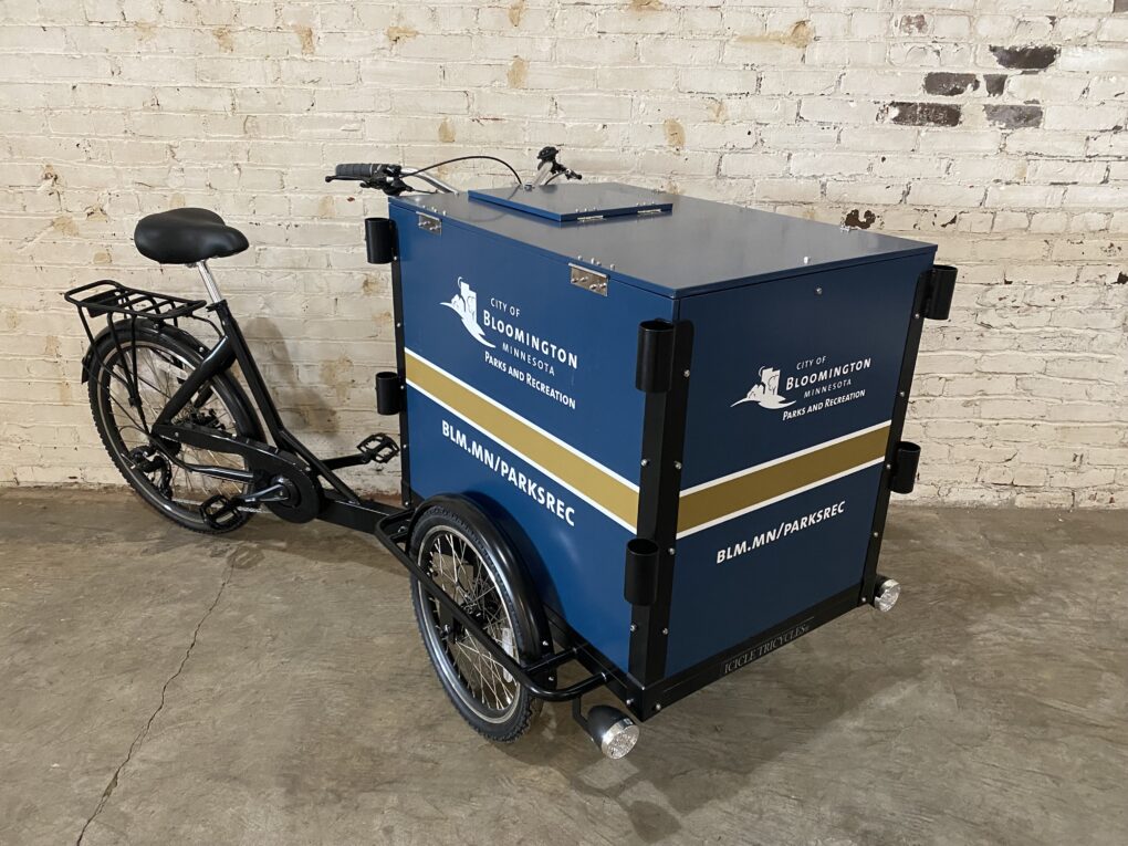 A Park Maintenance and Landscaping Bike for the city of Bloomington, MN in front of a white brick wall.